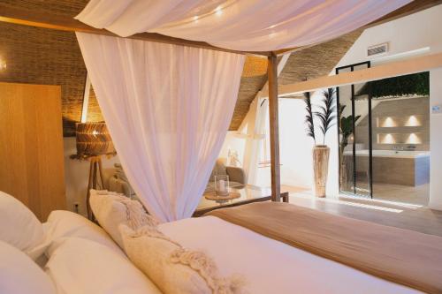 a bedroom with a bed with a canopy at La maison Balinaise in Haravilliers
