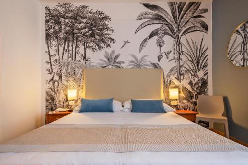 a bedroom with a bed with palm trees on the wall at Hotel Al Sole Bardolino in Bardolino