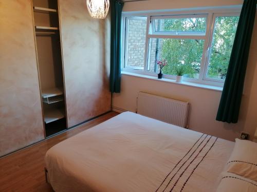 een slaapkamer met een wit bed en een raam bij Beautiful and peaceful large double bedroom near Olympic Park in Stratford London in Londen