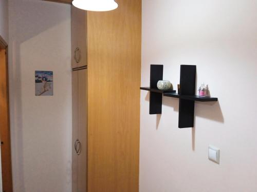 Habitación con nevera y 2 estanterías en la pared en Vassilis Apartments, en Paleokastritsa