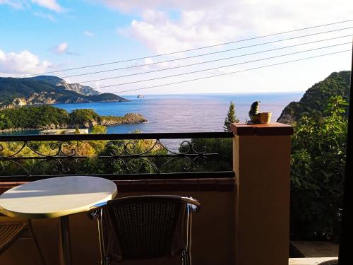 a balcony with a table and a view of the ocean at Vassilis Apartments in Paleokastritsa