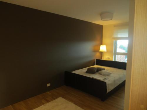 a bedroom with a bed with a black wall at Aida 7 Guest Apartement in Pärnu
