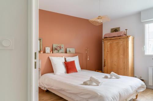 une chambre avec un grand lit blanc avec des murs orange dans l'établissement Appartement en centre-ville et face à l'Erdre, à Nantes