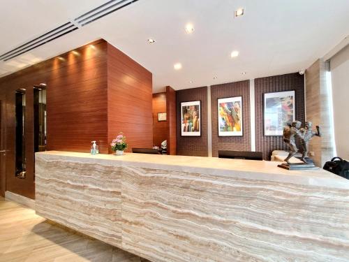 a lobby with a reception desk with a statue at On 8 Sukhumvit Nana Bangkok by Compass Hospitality in Bangkok