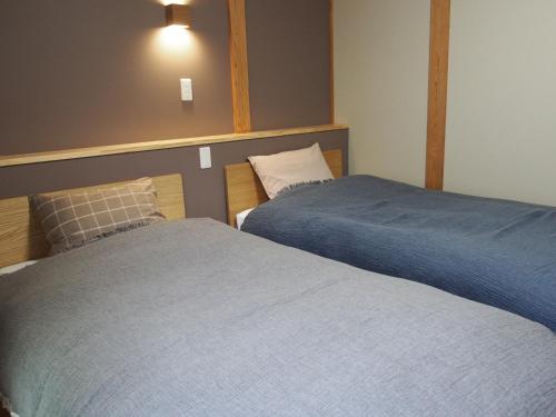 two beds sitting next to each other in a bedroom at Marushige in Nozawa Onsen
