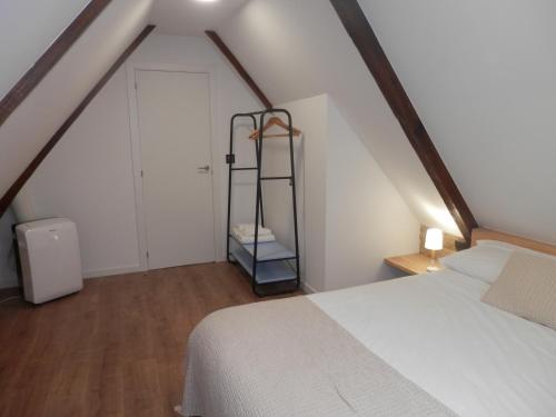 a attic bedroom with a white bed and a white door at Lar Azul in Redondela