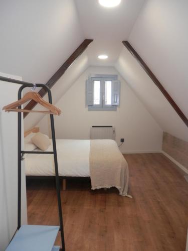 a attic bedroom with a bed and a ladder at Lar Azul in Redondela