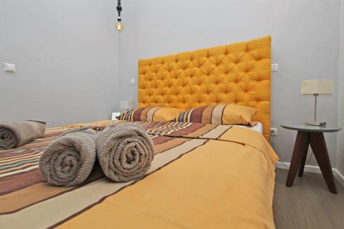 - une chambre avec un grand lit orange et des serviettes dans l'établissement WEST apartment in the heart of Sarajevo, à Sarajevo