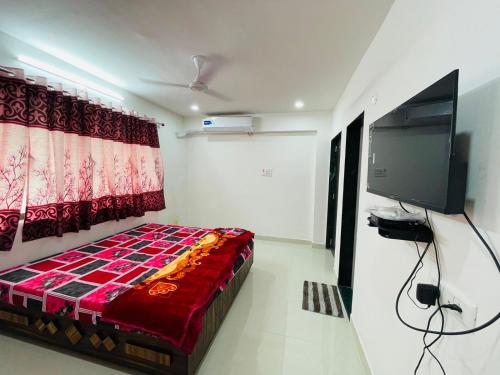 a bedroom with a bed and a television in a room at RJ Villa farmhouse in Daman