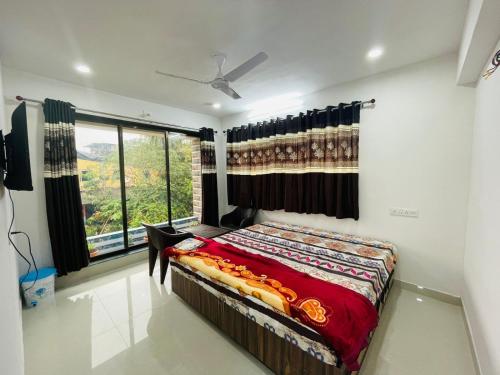 a bedroom with a bed and a large window at RJ Villa farmhouse in Daman