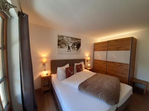 a bedroom with a large white bed and two lamps at Hochalmbahnen Chalets 8W1, Waldrebe, nahe Gondel, Hunde willkommen in Rauris
