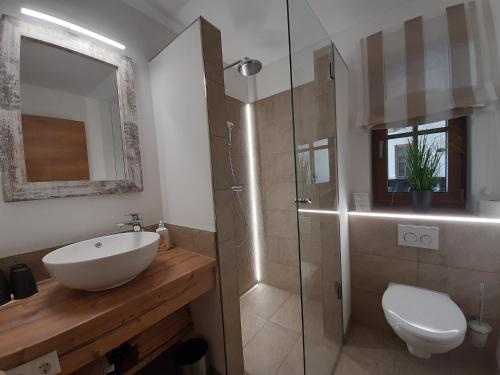 La salle de bains est pourvue d'un lavabo et d'une douche en verre. dans l'établissement Hochalmbahnen Chalets Rauris 1-08WE1, Maislaufeldweg 1e EG, à Rauris
