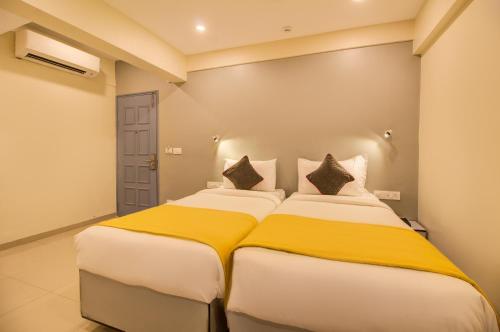 a bedroom with two beds in a room at Housemate Hotel in Pune