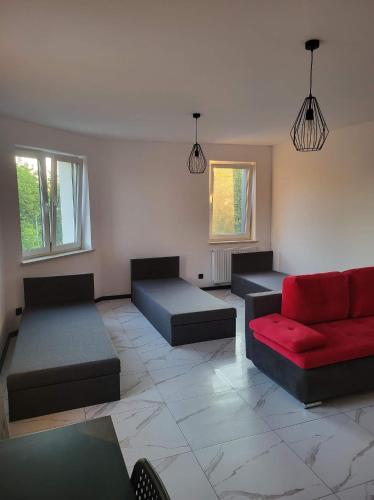 una sala de estar con 2 sofás y un sofá rojo. en Mieszkanie na wyłączność, en Radomsko
