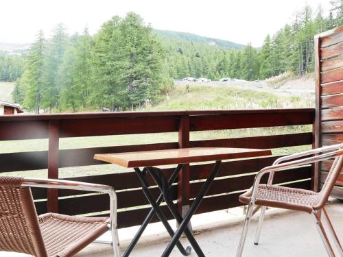 - une table et deux chaises sur une terrasse couverte avec vue dans l'établissement Appartement de standing avec piscine, sauna, hammam et WiFi - FR-1-322-70, aux Orres