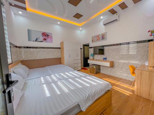 a bedroom with a large white bed in a room at Homestay Qhome in Con Dao