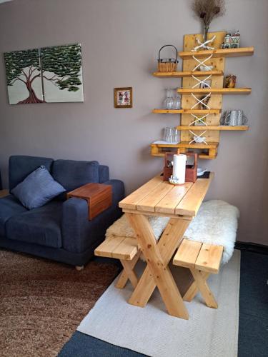 - un salon avec une table en bois et un canapé bleu dans l'établissement Kwinet Luxury Villa, à Eldoret