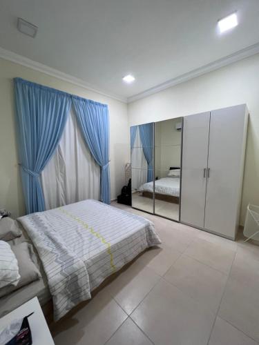 杜哈的住宿－Sasna，一间卧室配有一张大床和镜子