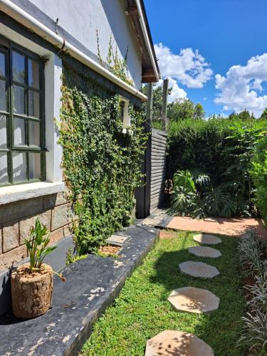 - un jardin avec une passerelle en pierre à côté d'une maison dans l'établissement Kwinet Luxury Villa, à Eldoret
