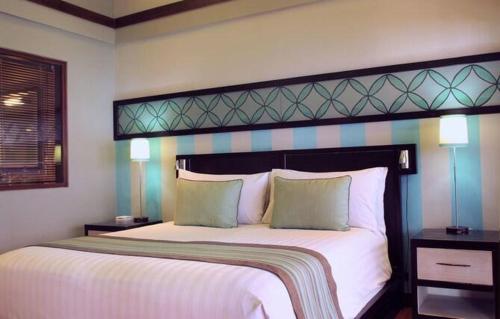 a bedroom with a large white bed with two pillows at Cinta inn in Ubud