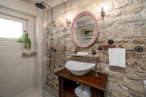 een badkamer met een wastafel en een spiegel bij Villa Little Arya in Otok