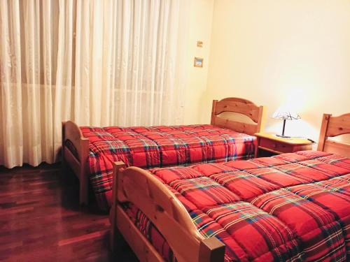 una camera d'albergo con due letti e una finestra di Casa Bianchi ad Asiago
