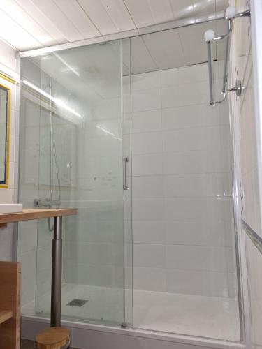 une douche avec une porte vitrée dans une salle de bain dans l'établissement Le Panorama, à Biarritz