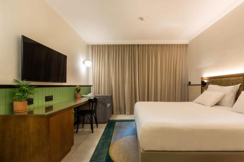 a hotel room with a bed and a desk at Ramat Rachel Resort in Jerusalem
