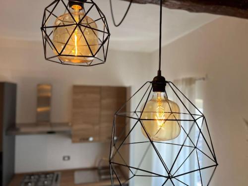 two lights hanging from a ceiling in a kitchen at Ottanio Lake Apartment in Pisogne