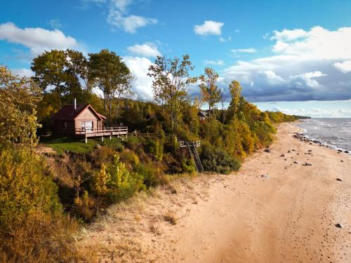 a house on a hill next to a beach at Jūras Pērle in Tūja