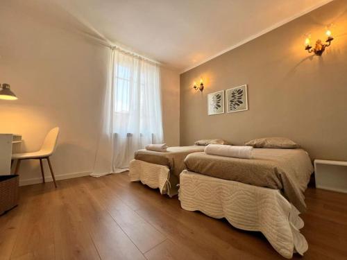 - une chambre avec 2 lits, une table et une fenêtre dans l'établissement Ottanio Lake Apartment, à Pisogne