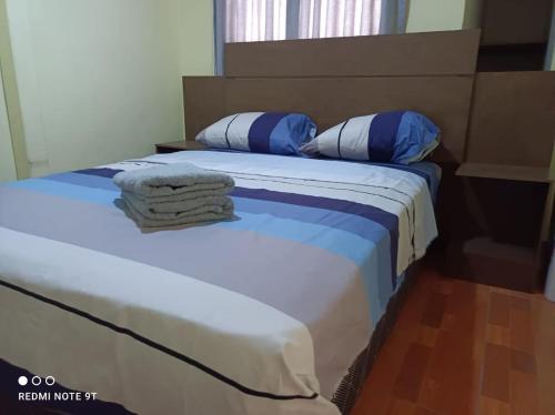 een slaapkamer met 2 bedden met blauwe en witte kussens bij LIndo departamento a 10 min en bus al centro historico de Lima in Lima