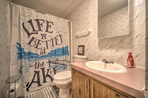 La salle de bains est pourvue d'un lavabo, de toilettes et d'un rideau de douche. dans l'établissement Quaint Cottage Overlooking Cherokee Reservoir, à Bean Station