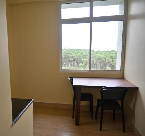 comedor con mesa, 2 sillas y ventana en TreeTops Residency, en Shillong