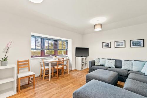 a living room with a couch and a table at Aspen Apartment in Helensburgh