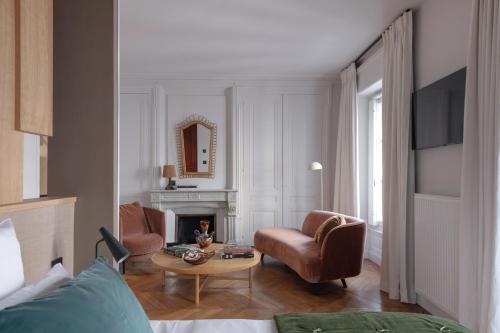 a living room with a fireplace and a chair and a table at MiHotel Plat in Lyon