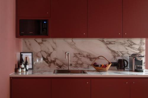 a kitchen with red cabinets and a sink and a counter at MiHotel Plat in Lyon