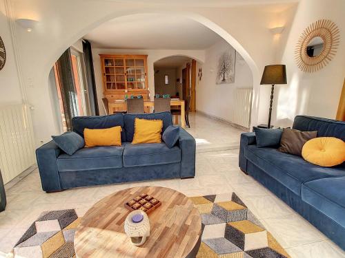 un salon avec deux canapés bleus et une table dans l'établissement Villa Les Cyprés, à Flayosc