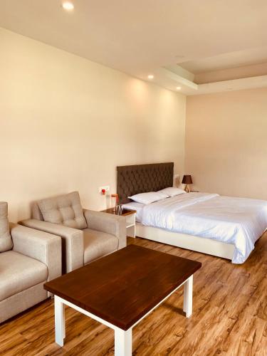 a bedroom with a bed and a couch and a table at THE APARTMENT in Gangtok