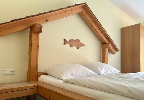 - une chambre avec un lit et un panneau de poisson sur le mur dans l'établissement Fischerstüberl, à Gaishofen