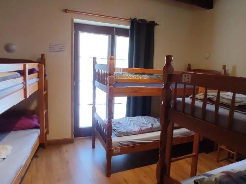 a room with three bunk beds and a window at Albergue La Senda in Rabanal del Camino