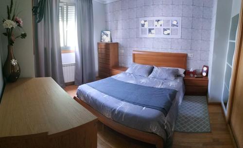1 dormitorio con 1 cama con edredón azul en Chalet Adosado, en Moaña