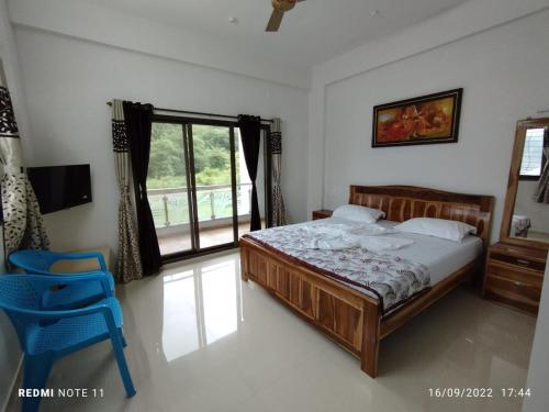 a bedroom with a bed and a blue chair at Hotel Kavijay Sea View in Dapoli