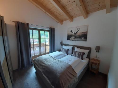 une chambre avec un grand lit et une fenêtre dans l'établissement Hochalmbahnen Chalets Rauris 1-15 WE2, Maislaufeldweg 1o OG, à Rauris
