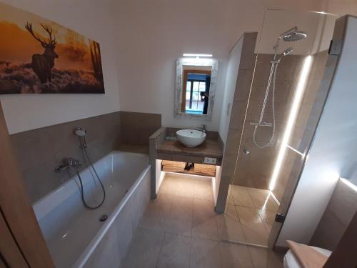 une salle de bain avec une baignoire, un lavabo et une douche dans l'établissement Hochalmbahnen Chalets Rauris 1-15 WE2, Maislaufeldweg 1o OG, à Rauris