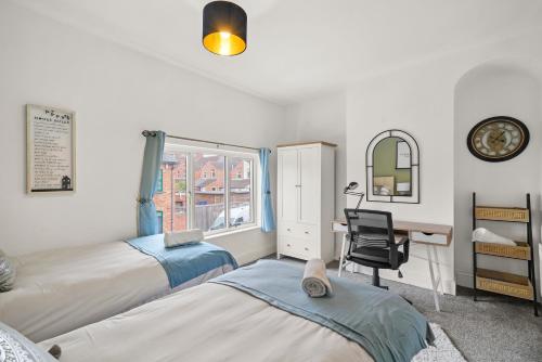 a bedroom with two beds and a desk and a window at Central House with Parking, Pool Table, Super-Fast Wifi and Smart TV with Virgin TV and Netflix by Yoko Property in Northampton