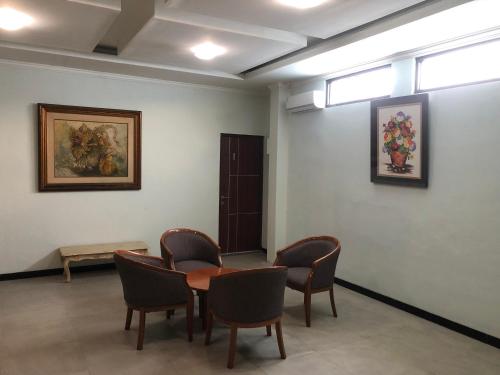 een wachtkamer met een tafel en stoelen bij Bening Asri Guesthouse in Gombolpaya