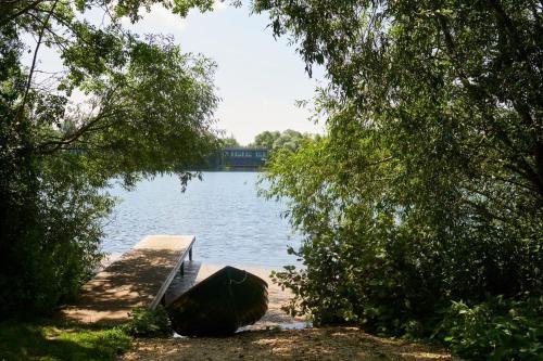 a dock on a body of water with trees at The Lakes By YOO in Lechlade