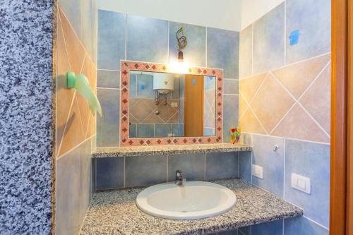 y baño con lavabo y espejo. en Orosei RE - Villa Osala - 800 m dal mare, en Orosei