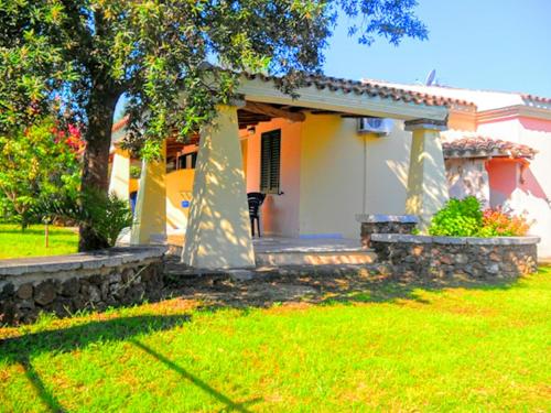 a small white house with a porch in a yard at Orosei RE - Villa Osala - 800 m dal mare in Orosei